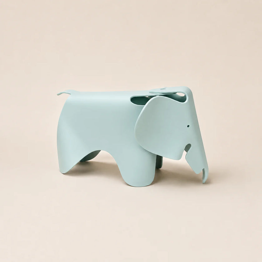 A light blue elephant-shaped stool with a matte finish, shown from a side profile against a solid beige background.