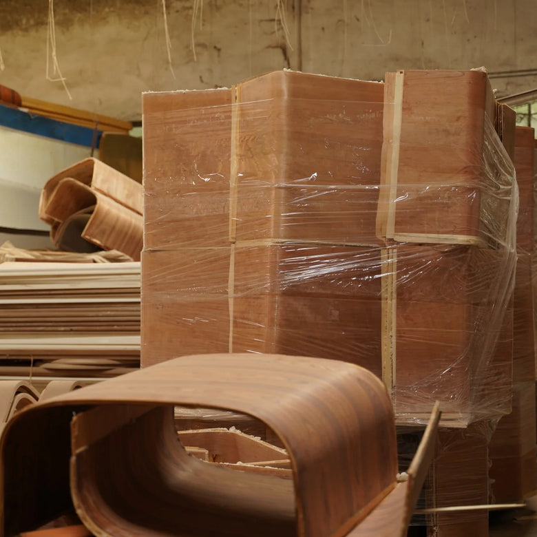 Stacks of brown cardboard boxes with plastic wrap in a warehouse setting