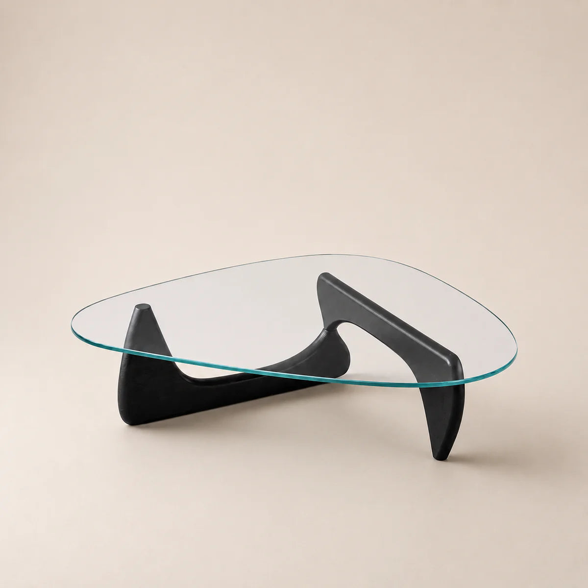 Modern glass coffee table with black curved legs on a beige background
