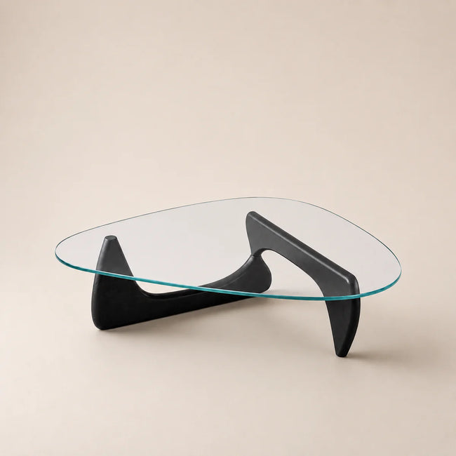 Modern glass coffee table with black curved legs on a beige background