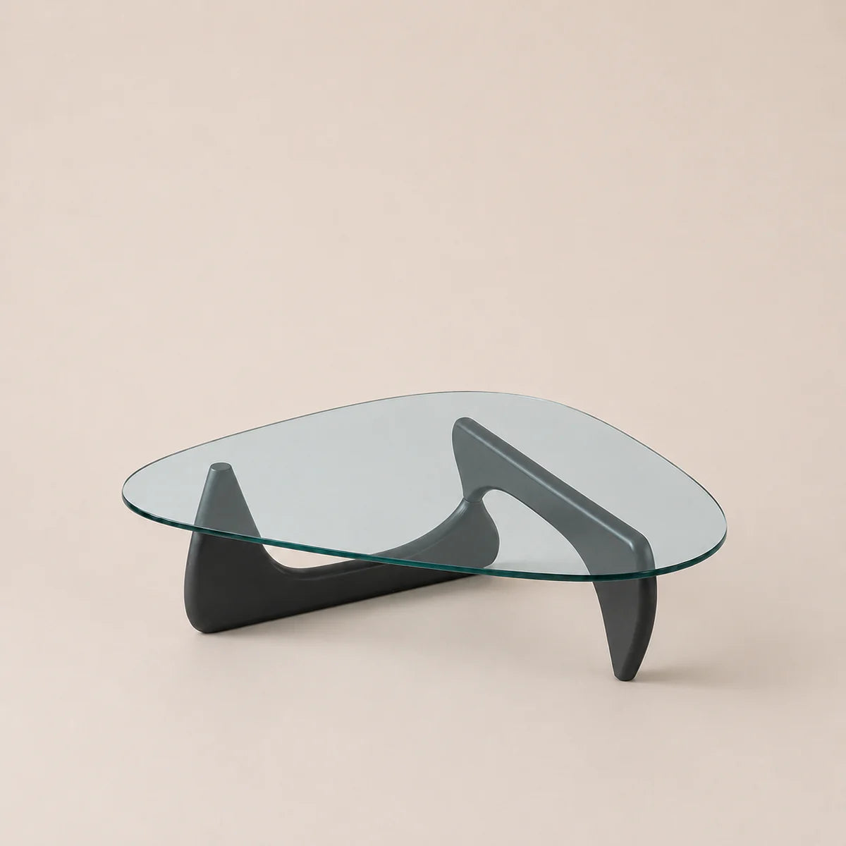 Modern glass coffee table with black legs on a beige background