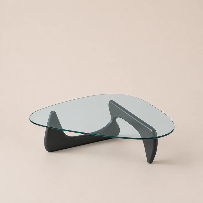 Modern glass coffee table with black legs on a beige background