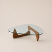 Glass coffee table with wooden base on a beige background