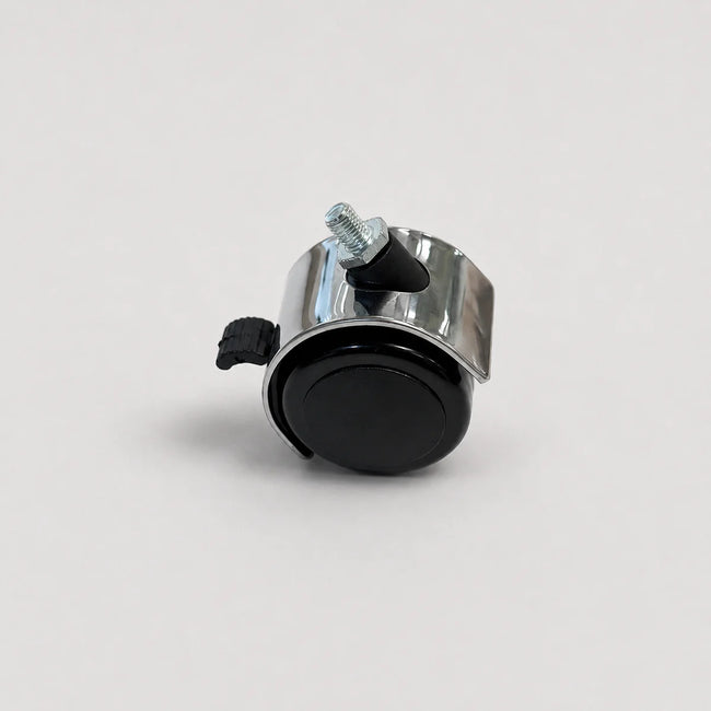 A small metal wheel assembly with a black circular wheel, a shiny silver metal frame, a black plastic clip, and a silver threaded bolt, photographed on a light gray background.