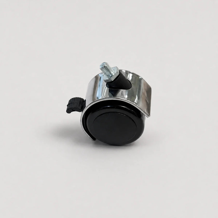 A small metal wheel assembly with a black circular wheel, a shiny silver metal frame, a black plastic clip, and a silver threaded bolt, photographed on a light gray background.