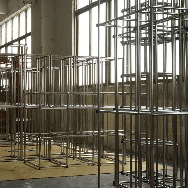 Metal scaffolding structures in a large indoor space with high ceilings.