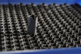 Small cylindrical object on a textured surface with a blue background