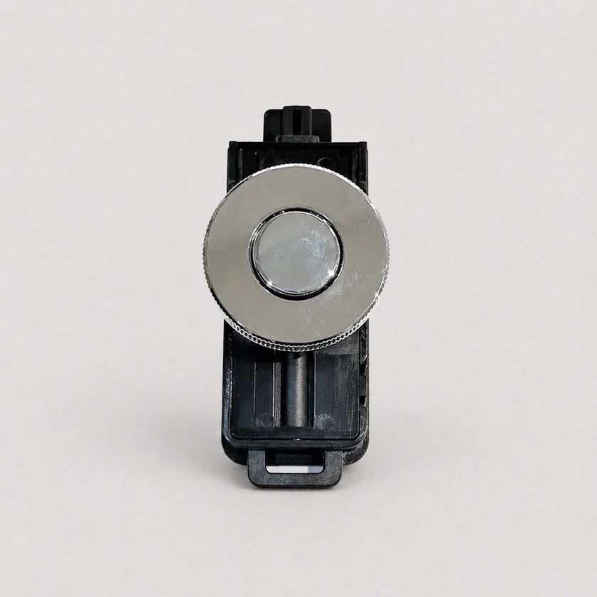 A replacement button component for a device, featuring a round silver metallic button with a textured outer ring, mounted on a black plastic housing, shot against a light gray background.