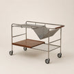 Metal trolley with wooden shelves on a beige background
