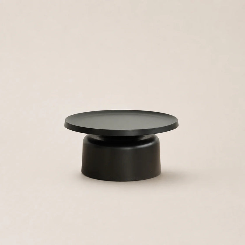 Black round coffee table on a beige background