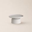 Two-tiered white table on a beige background