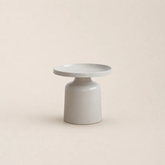 Minimalist ceramic table with a round top and cylindrical base on a beige background