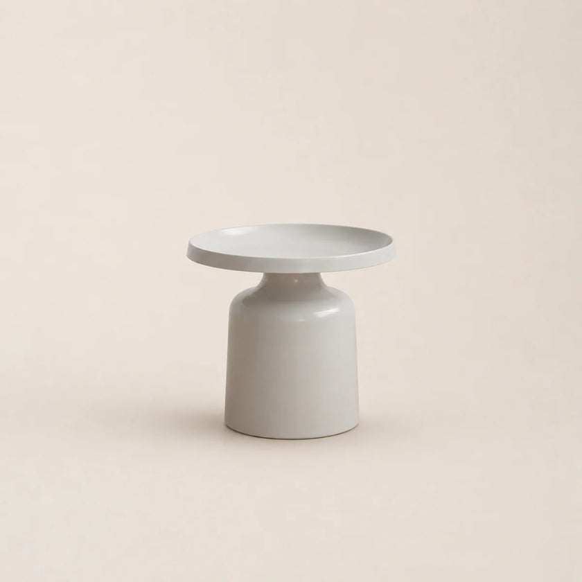 Minimalist ceramic table with a round top and cylindrical base on a beige background