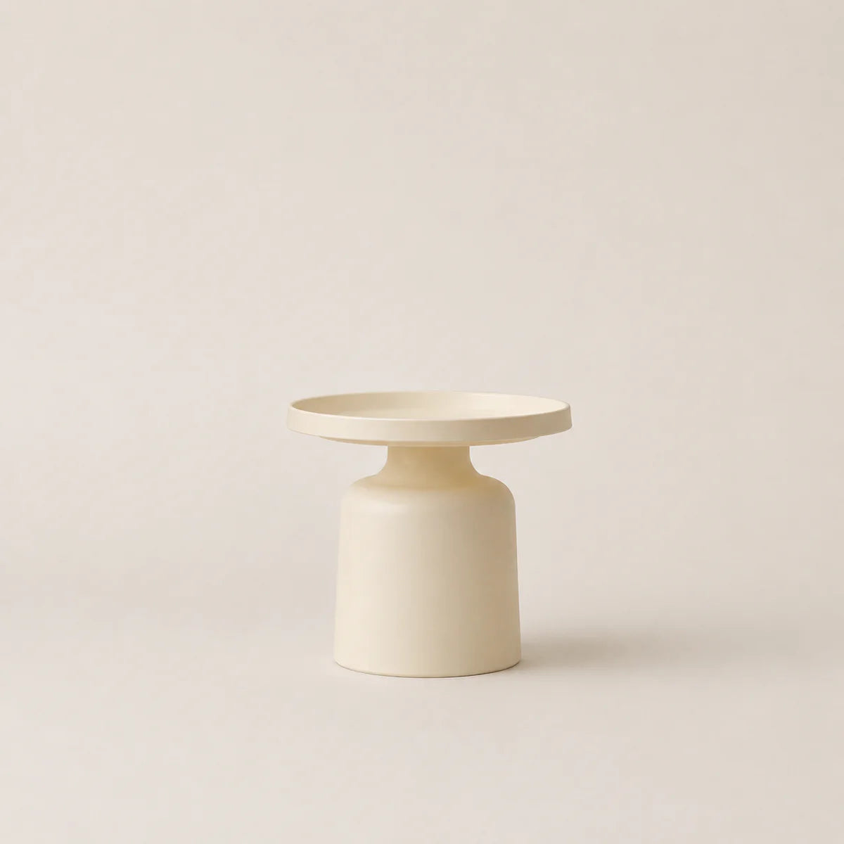 Minimalist cream-colored side table on a light beige background