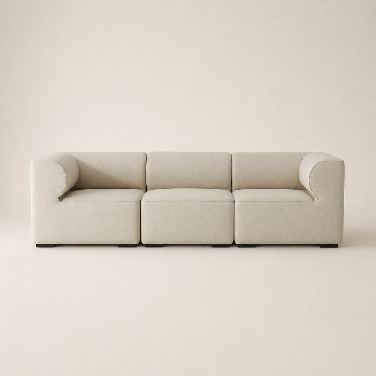 A modern three-seat modular sofa upholstered in a light beige fabric, featuring rounded armrests and a minimalist design, set against a solid warm beige background.