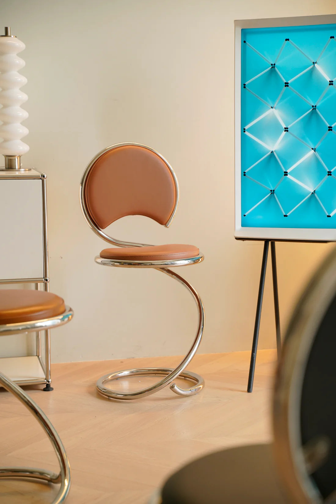 Modern high leather bar chair with a blue textured wall in a minimalistic room