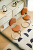 Three brown high chair with metal legs in front of a white dresser.
