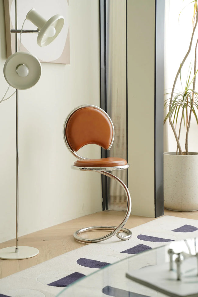 Modern brown bar chair in a room with a floor lamp and plant