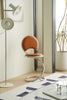 Modern brown bar chair in a room with a floor lamp and plant