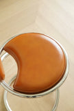 Brown leather high bar chair with metal frame on a light wooden floor