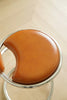Brown leather high bar chair with metal frame on a light wooden floor
