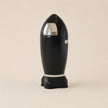 Black cylindrical device with a reflective surface on a beige background