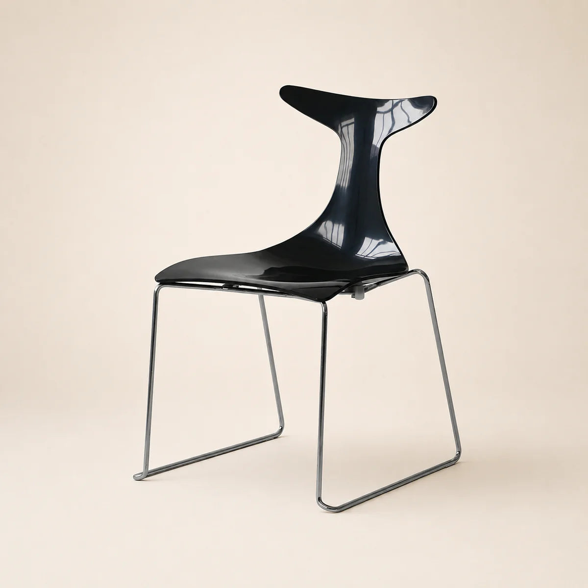 Modern black chair with a minimalist design on a beige background