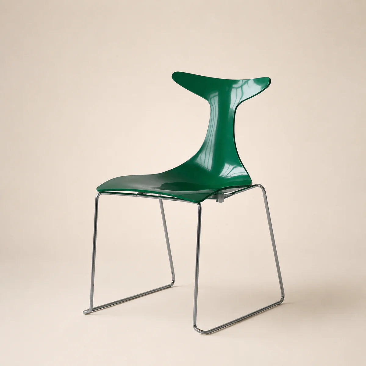 Green chair with metal legs on a beige background