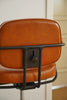 Brown leather office chair with black metal frame against a neutral background