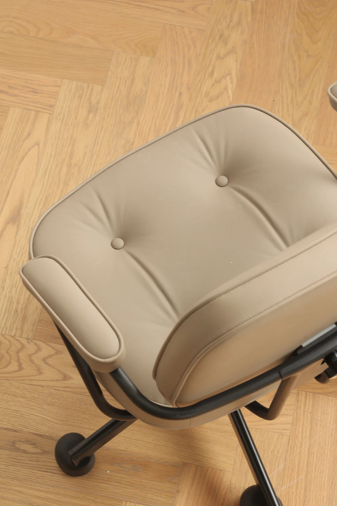 Beige office swivel arm chair cushion on a wooden floor
