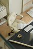 Beige office chair in a modern office setting with a desk, keyboard, and book.