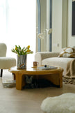 Living room with a round small coffee table, white sofa, and decorative items.