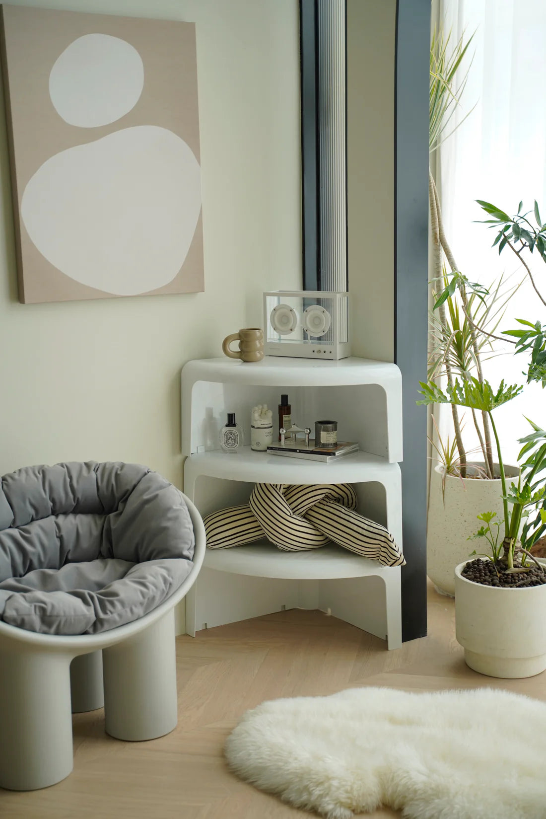 Modern interior with a white chair, small coffee table with storage, and plants.