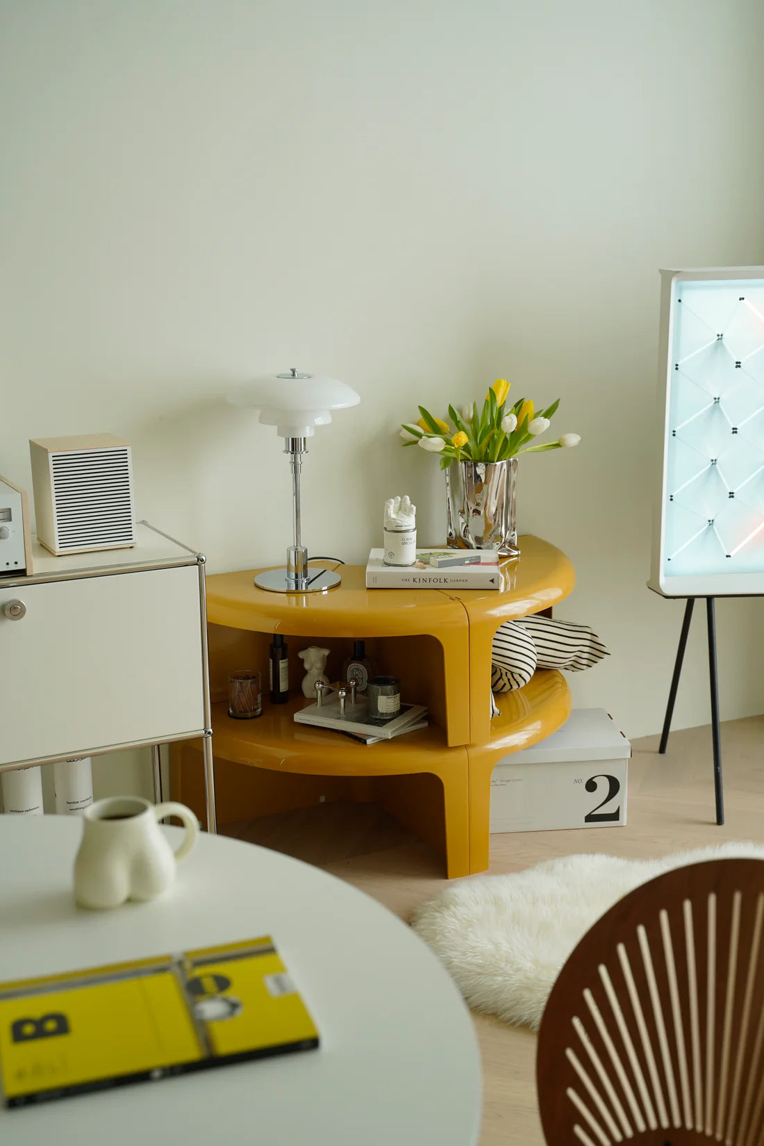 Round yellow counter side table with decorative items in a room setting