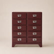 Red dresser with multiple drawers on a beige background