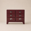 Red dresser with silver handles on a beige background