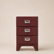 Red metal file cabinet with three drawers on a beige background