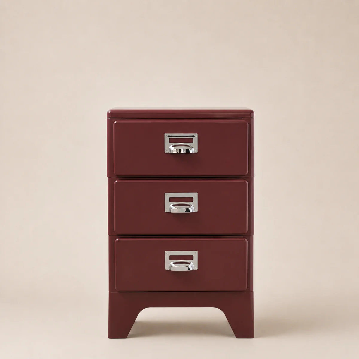 Red metal file cabinet with three drawers on a beige background