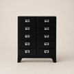 Black dresser with multiple drawers on a beige background