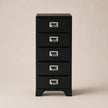 Black metal file cabinet with four drawers on a beige background