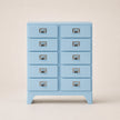 Light blue dresser with multiple drawers on a beige background