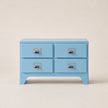 Light blue four-drawer chest with silver handles on a beige background