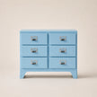 Light blue dresser with six drawers on a beige background