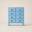 Light blue chest of drawers with six drawers on a beige background