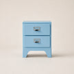 Light blue nightstand with two drawers on a beige background