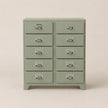 Green dresser with multiple drawers on a beige background