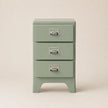 Green three-drawer nightstand with metallic handles on a beige background