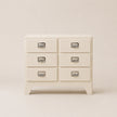 Beige dresser with silver handles on a beige background