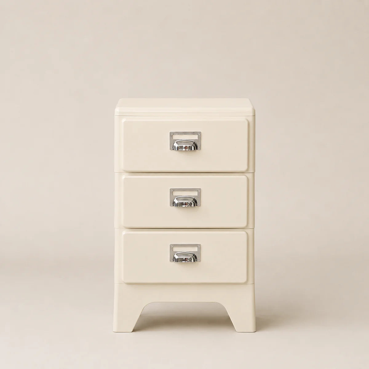 Cream-colored nightstand with three drawers on a beige background