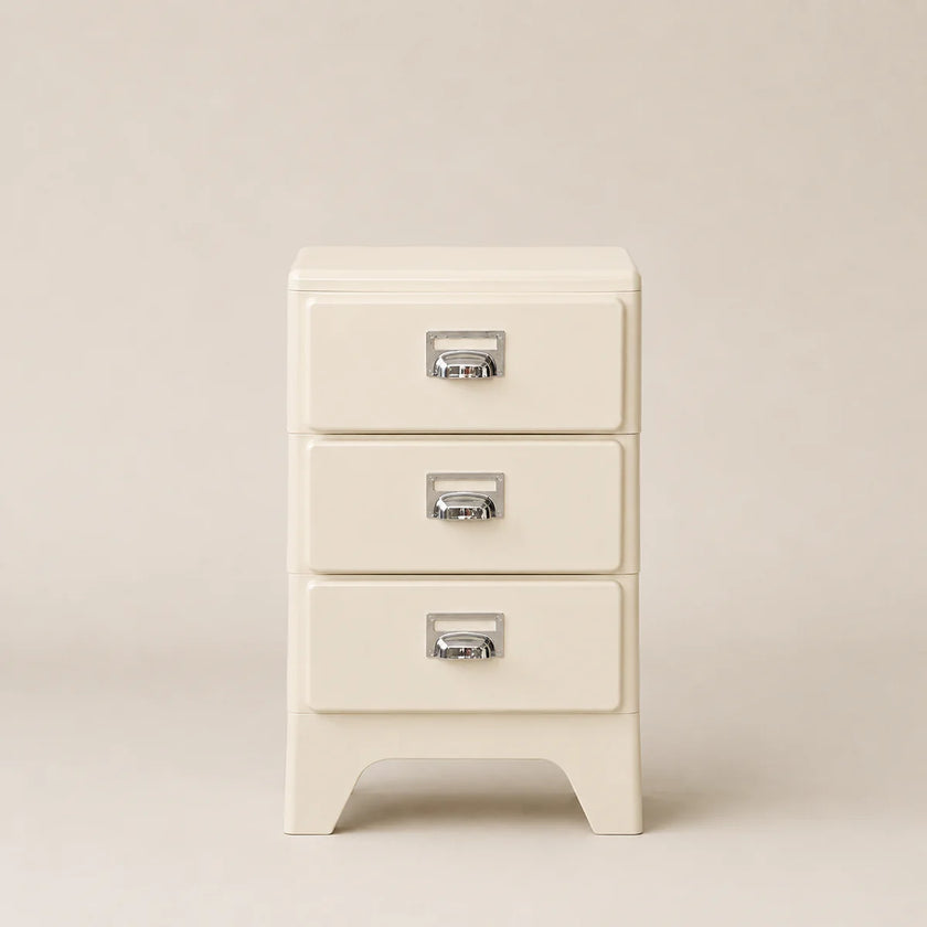 Cream-colored nightstand with three drawers on a beige background